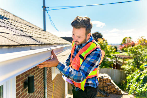 A man standing on steps inspecting house roof A man standing on steps inspecting house roof